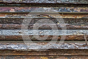 A layer of sawn boards with bark