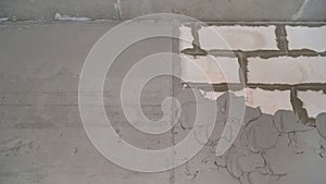 A layer of wet mortar of finishing putty, leveling the wall, with gypsum plaster, building the background. Plastered walls made of