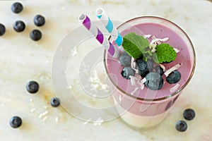 Layered blueberry and coconut smoothie, downward view over marble