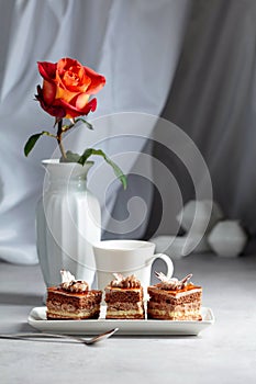 Layered cakes with rose on a white marmorean table