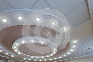 Layered ceiling with embedded lights and stretched ceiling inlay