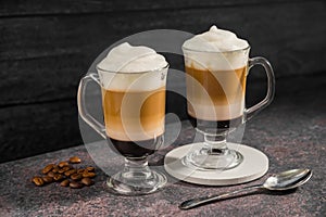 Layered coffee latte drinks. Hot coffee drinks in glass mugs, dark background