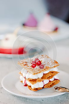 Layered cream dessert Millefeuille with vanilla cream and red berries