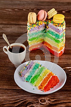 Layered delicious homemade rainbow cake with cup of coffee