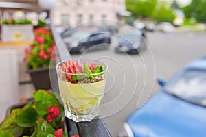 Layered dessert with fruit and cream cheese in glass jar, selective focus. Strawberry milk dessert in a small glass