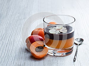 Layered dessert in glass with apricot jelly with chocolate mousse