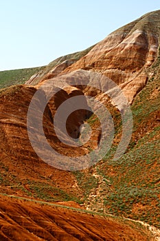 Layered eroded mountains with the green grassy slope
