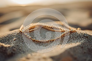 Layered golden anklet glistening on beach sand at sunset