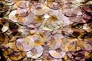 Layered photo illustration of silver and rose gold CD and DVD data storage disks