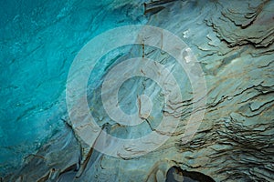 Layered rock formations with blue water