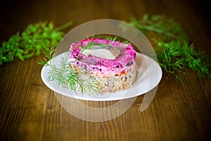 Layered salad of boiled vegetables with beets and herring