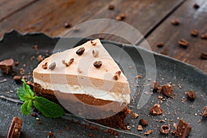 Layered souffle cake on black plate into wood