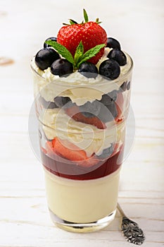 Layered strawberry dessert - panna cotta with berry jelly, blueberries and strawberries.