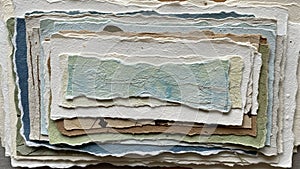 Of layered textured paper sheets each with deckled edges arranged in a