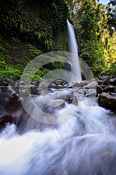 Layered water flows with cool air and green scenery are attractions that you can Sendeng Gile waterfall in Lombok, Indonesia.