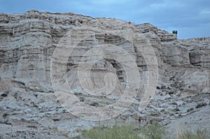 Layered white, gray hill in New Mexico under cloudy blue sky