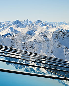 Layers of mountain peaks reflected on glass - view from Parpaner Rothorn upper cable station in Arosa Lenzerheide resort.