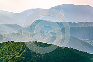 Layers of mountains in the haze during sunset. Beautiful sunset in the hills and mountains. Beautiful sunset in a hilly valley