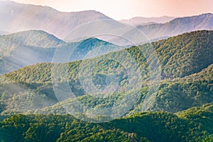 Layers of mountains in the haze during sunset. Beautiful sunset in the hills and mountains. Beautiful sunset in a hilly valley