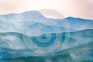 Layers of mountains in the haze during sunset. Beautiful sunset in the hills and mountains. Beautiful sunset in a hilly valley