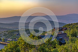 Layers of sunset hills with homes foreground