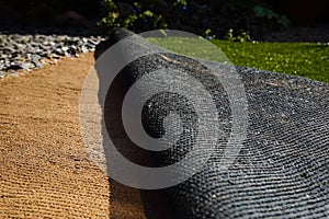 Laying artificial grass turf onto sand photo