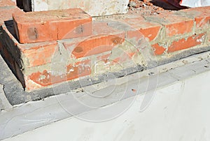 Laying bricks on the concrete foundation, footing, base covered with bitumen waterproofing membrane to prevent water damage