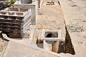 Laying concrete manholes and drain pipes for stormwater system. Connecting a trench drain to a concrete manhole