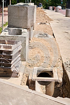 Laying concrete manholes and drain pipes for stormwater system. Connecting a trench drain to a concrete manhole