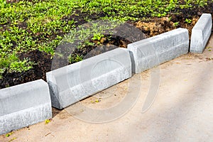 laying curb stones on a sidewalk in the city.