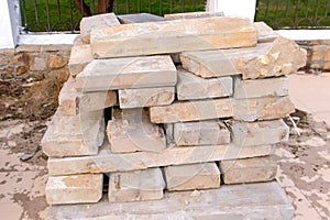 Laying dismantled old paving slabs in pile on sidewalk in city park.