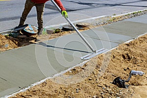 Laying down a new sidewalk in wet concrete on freshly poured sidewalks