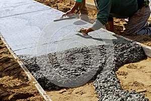 Laying down a new sidewalk in wet concrete on freshly poured sidewalks