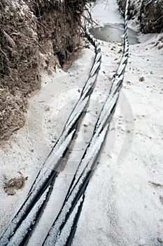 Laying a fiber optic and electricity cables in the frozen ground