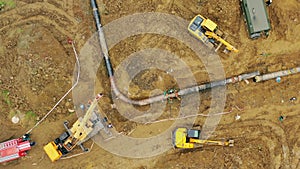 Laying a gas pipe. top view Workers and equipment are laying the pipeline. Engineering