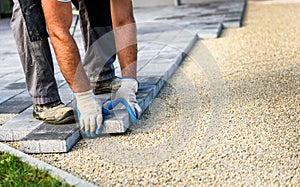 Laying gray concrete paving slabs in house courtyard driveway pa