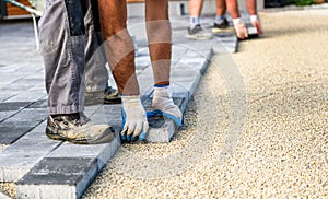 Laying gray concrete paving slabs in house courtyard driveway pa