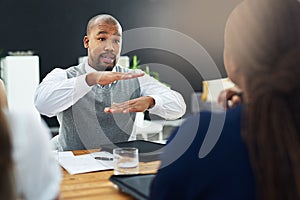 Laying the groundwork for a great business. a young businessman explaining something to two of his colleagues.