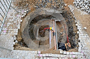 Laying high voltage cables to the ground. Excavation meter deep in the ground, black plastic coated strong cable wires. in case of