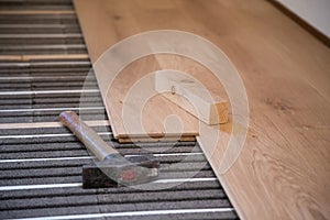 Laying and installing solid parquet above underfloor heating