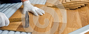 Laying laminate wood floor in the room - repair and finishing work.