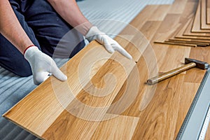 Laying laminate wood floor in the room - repair and finishing work.