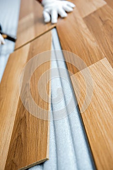 Laying laminate wood floor in the room - repair and finishing work.