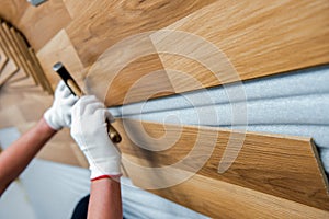 Laying laminate wood floor in the room - repair and finishing work.