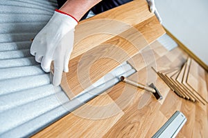 Laying laminate wood floor in the room - repair and finishing work.