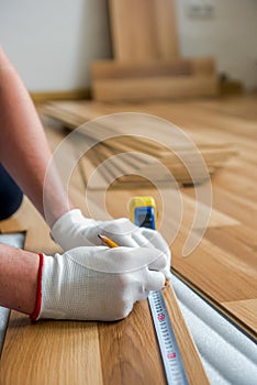 Laying laminate wood floor in the room - repair and finishing work.