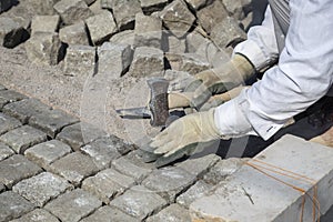 Laying natural granite stone cobbles in sand