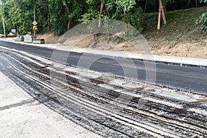 Laying a new asphalt on the road. Layer of fresh hot asphalt on the street