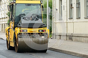 Laying of new modern asphalt. Asphalt laying equipment works on the site. A yellow asphalt skating rink rides in close-up on a new