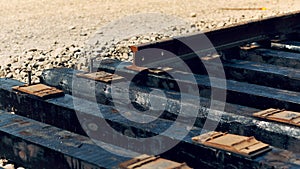 Laying of new railway tracks with wooden sleepers laid on groundwork crushed stone.